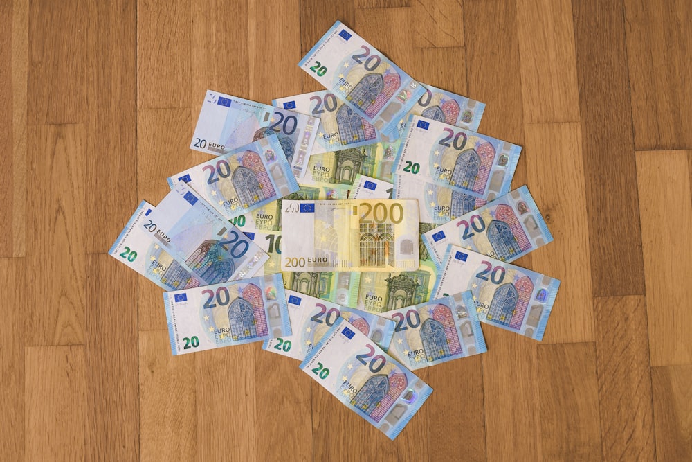 10 und 10 Banknoten auf braunem Holztisch