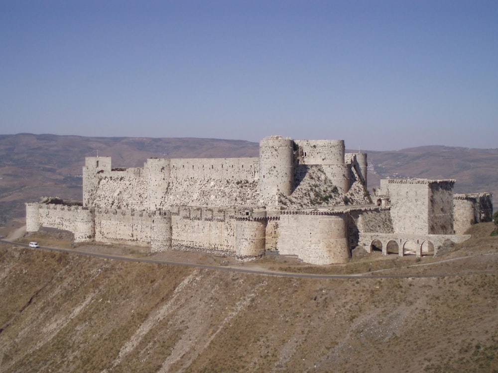 gray concrete castle on green grass field under blue sky during daytime