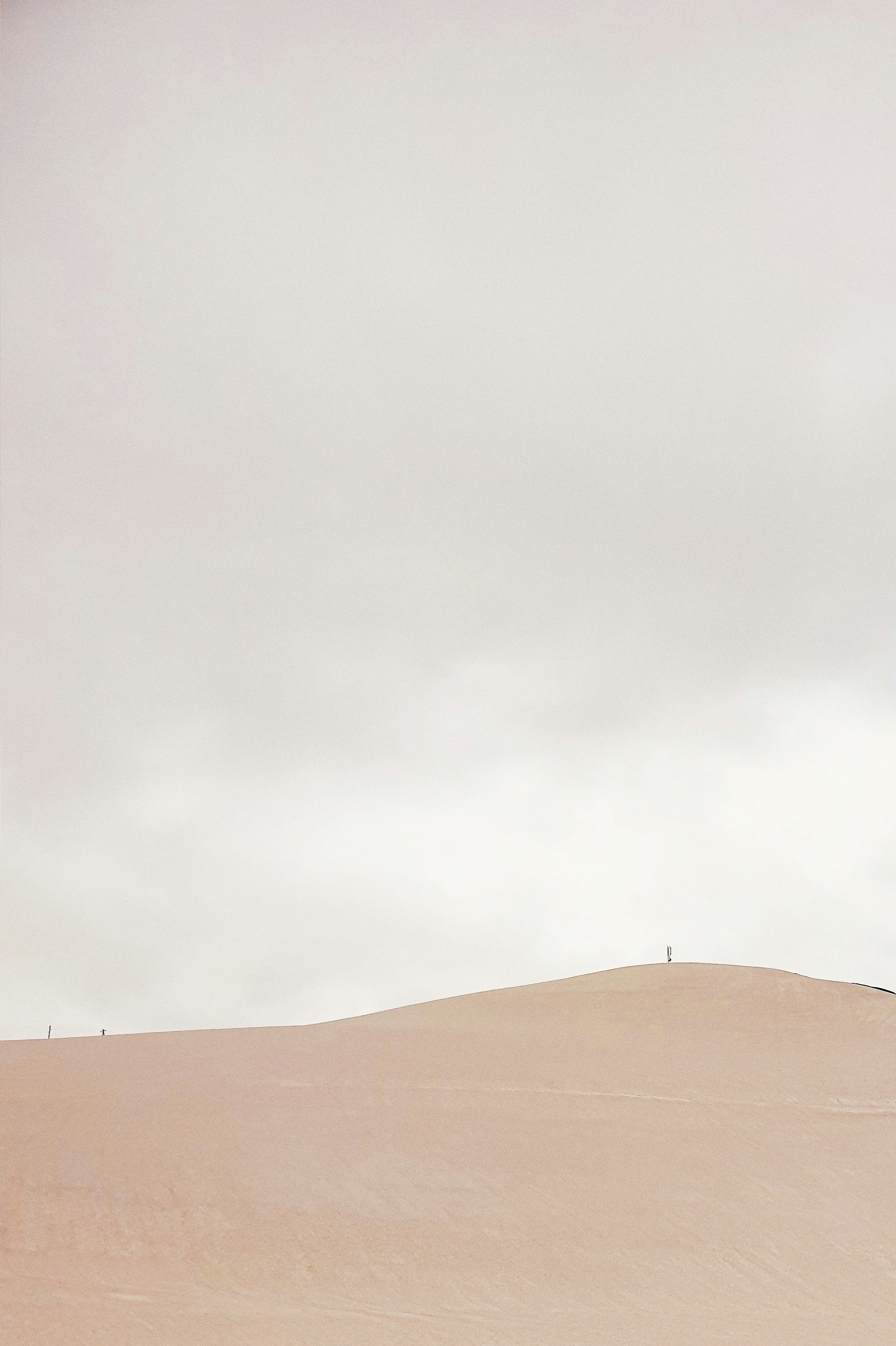 sabbia marrone sotto il cielo bianco durante il giorno