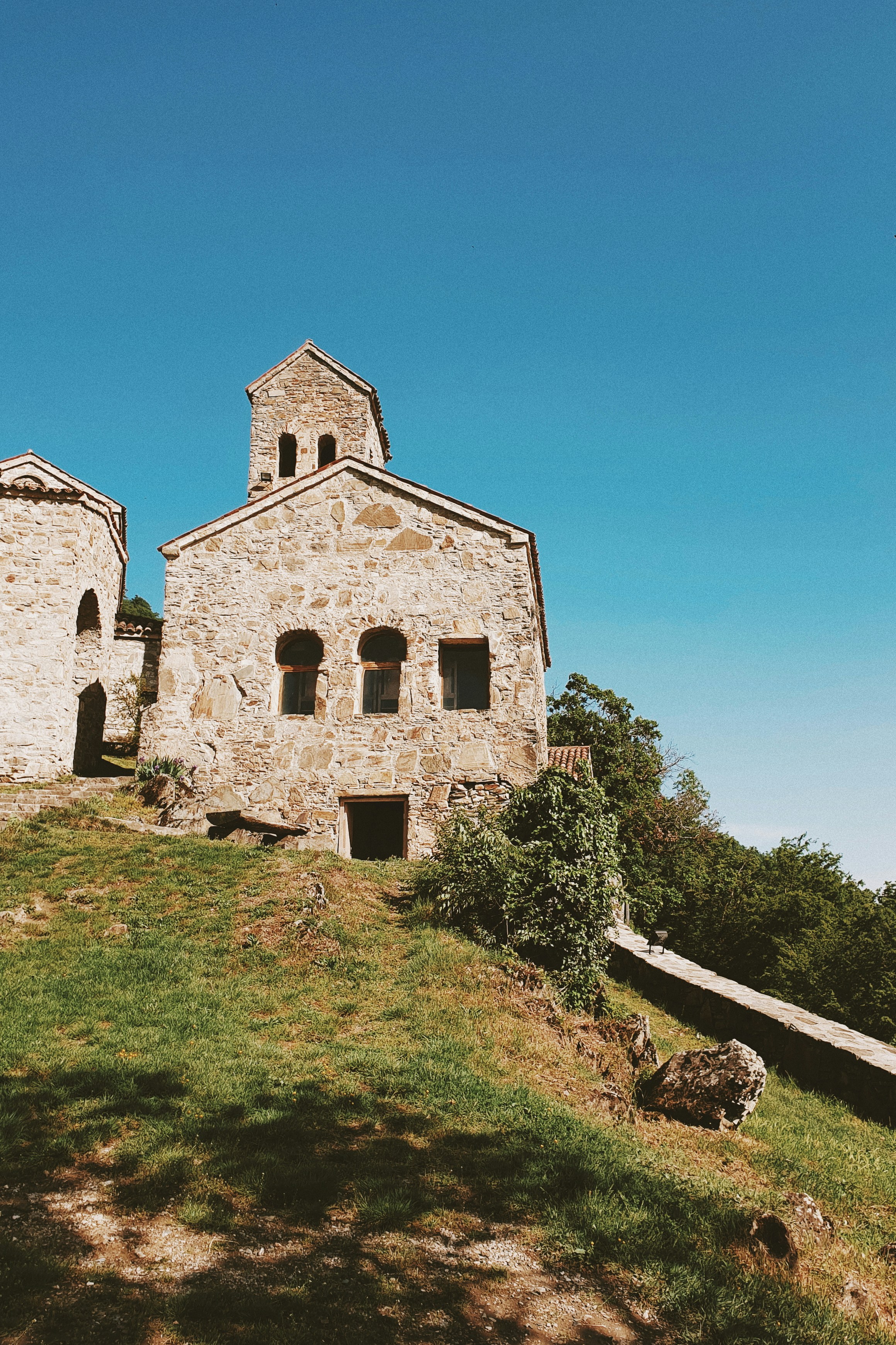 edificio in cemento marrone vicino al campo di erba verde durante il giorno