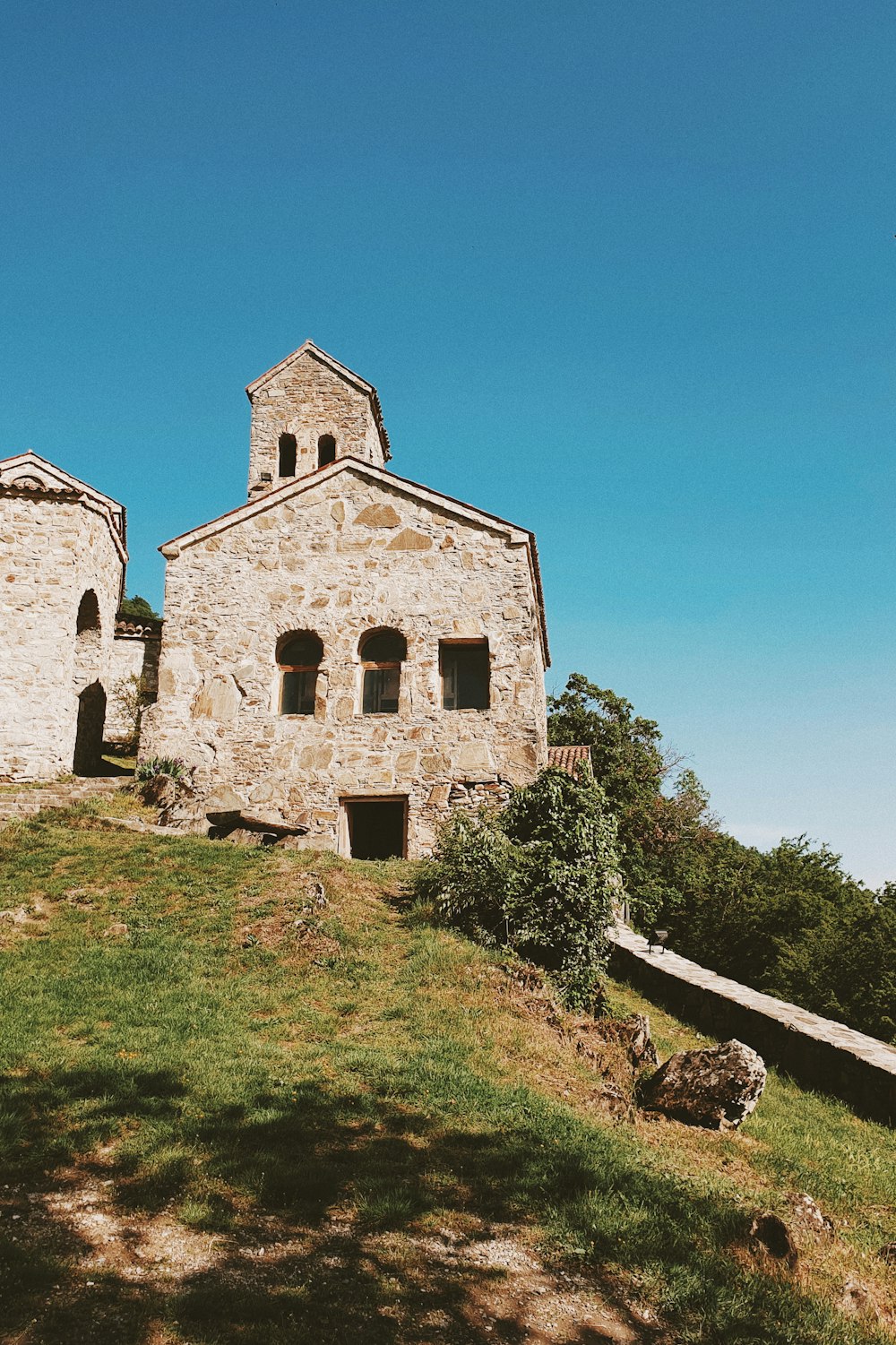 edificio in cemento marrone vicino al campo di erba verde durante il giorno