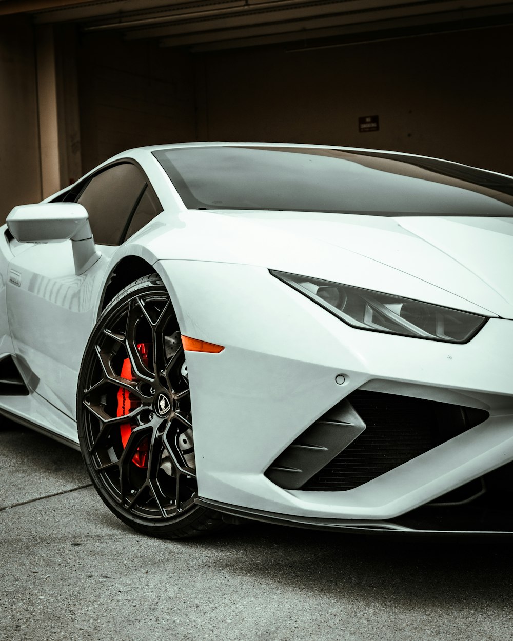 white lamborghini aventador parked on gray pavement