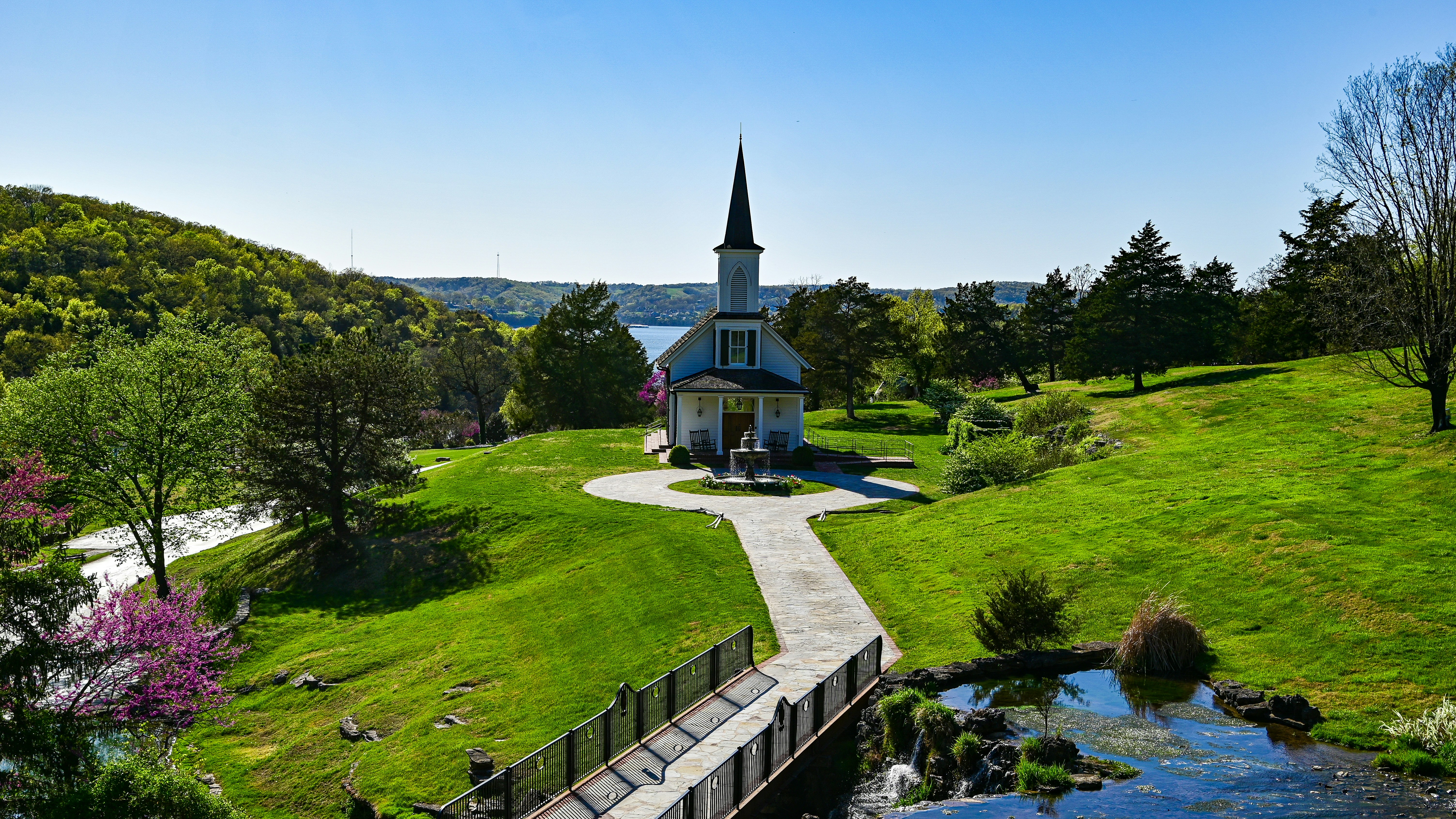 green and white concrete building surrounded by green grass field during daytime