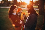 Warm family moment captured outdoors with golden hour sunlight casting gentle shadows.