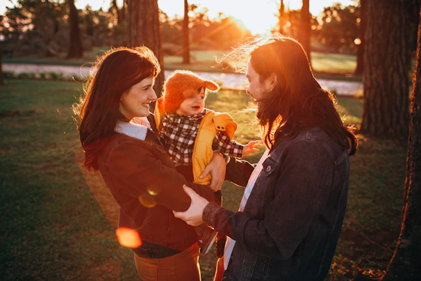 A warm family moment in a sunny Dubai park with city skyline in the background.