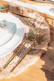 Close-up of a meticulously styled place setting featuring a custom menu card embossed in gold foil.