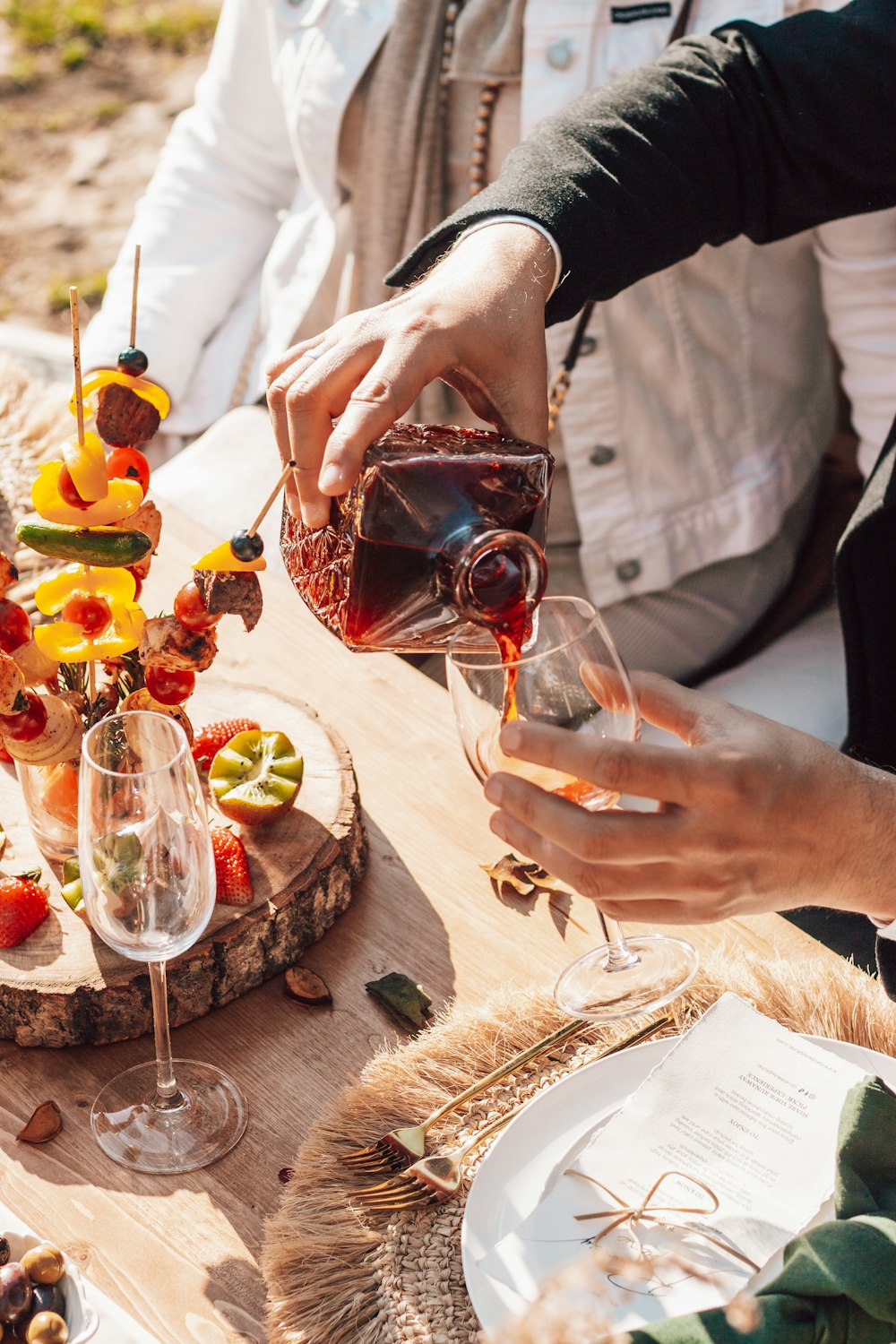 person pouring wine on wine glass