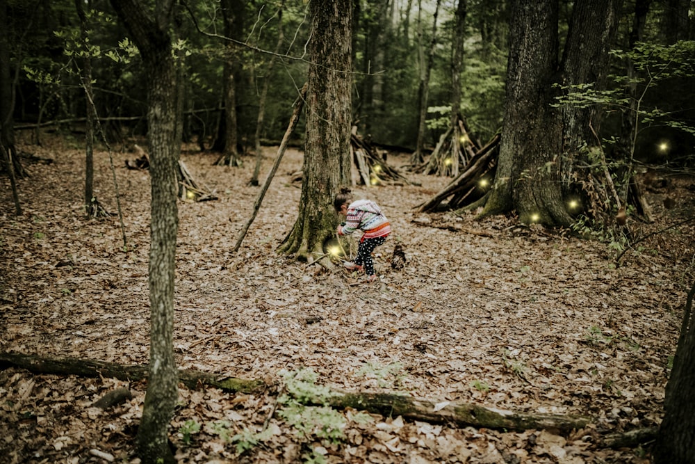 man in blue jacket riding motorcycle in forest during daytime