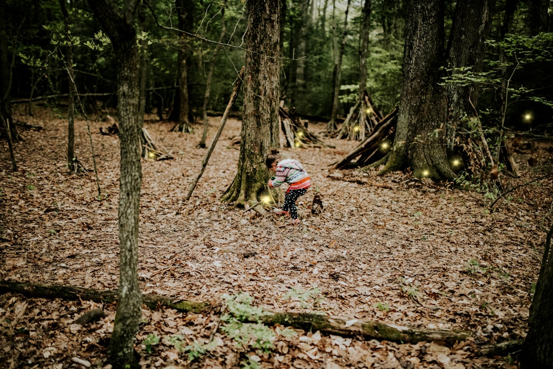 man in blue jacket riding motorcycle in forest during daytime