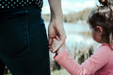 girl in pink jacket holding her hair