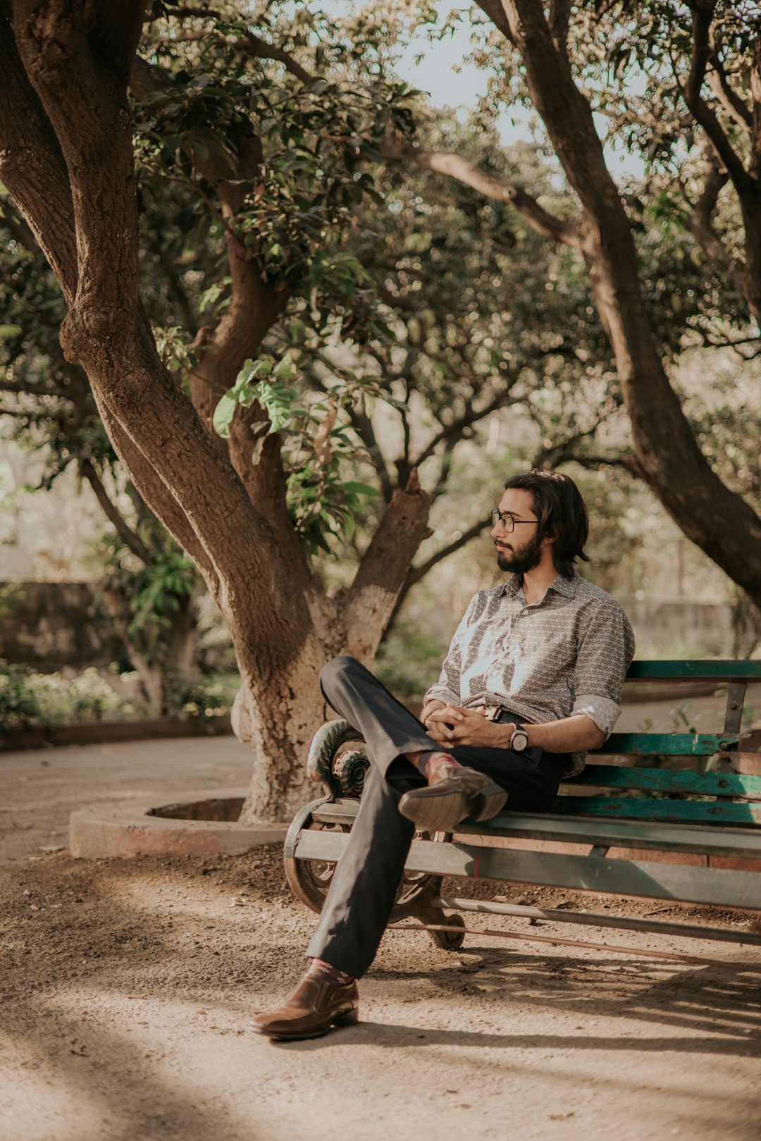 woman in gray long sleeve shirt sitting on brown wooden bench during daytime