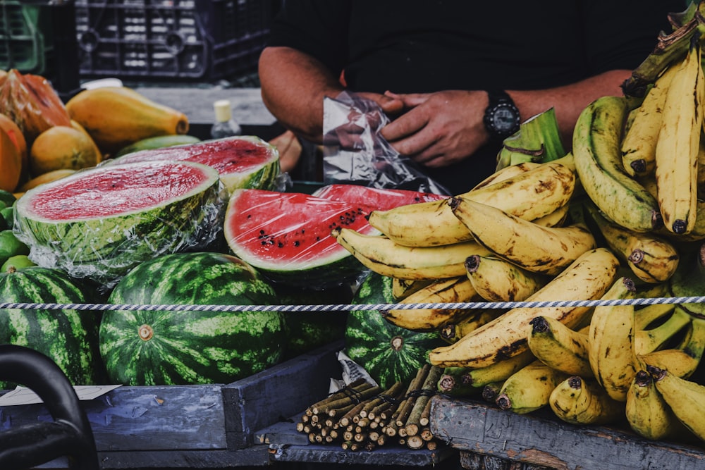 person holding banana fruit and watermelon