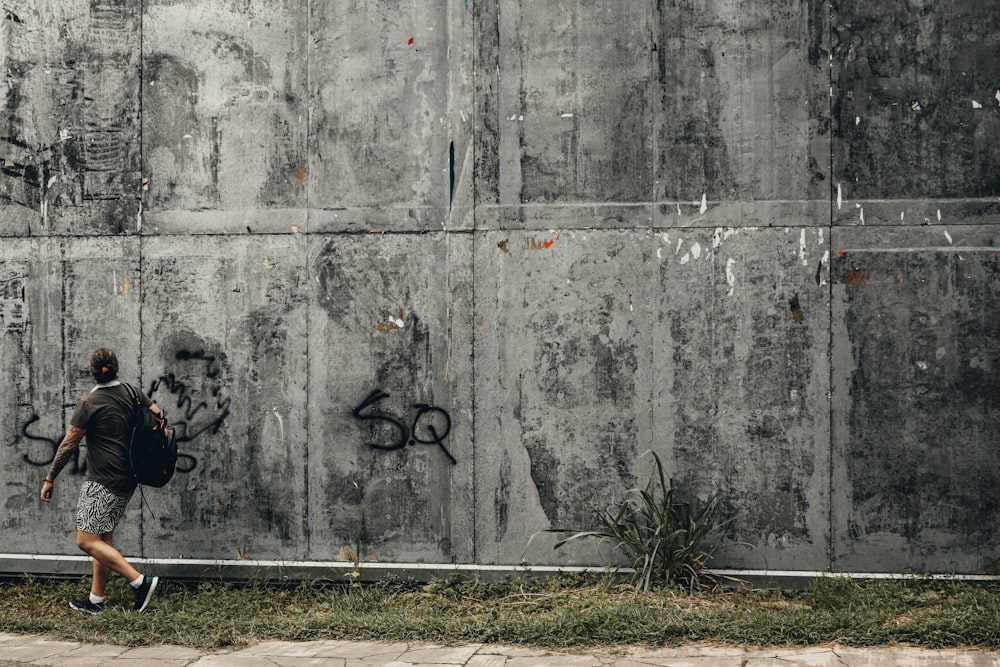 Bicicleta negra apoyada en una pared de hormigón gris durante el día