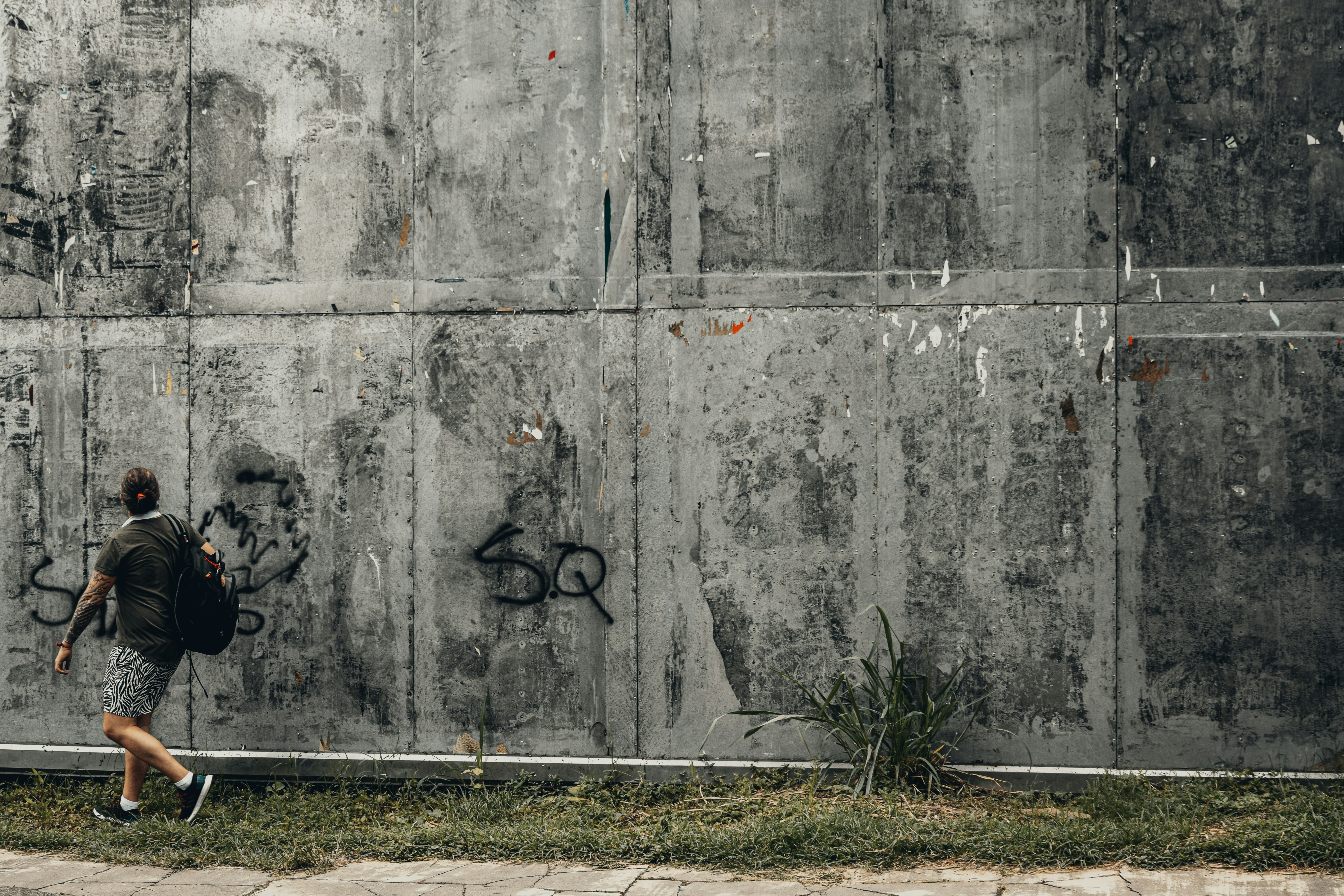 black bicycle leaning on gray concrete wall during daytime