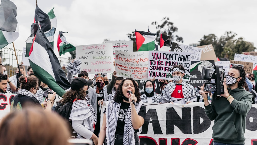 group of people standing near white and red banner