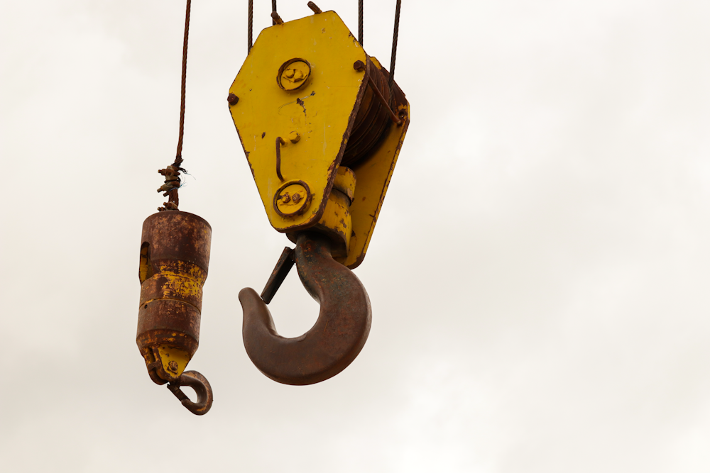 yellow and black bell hanging on yellow metal bar