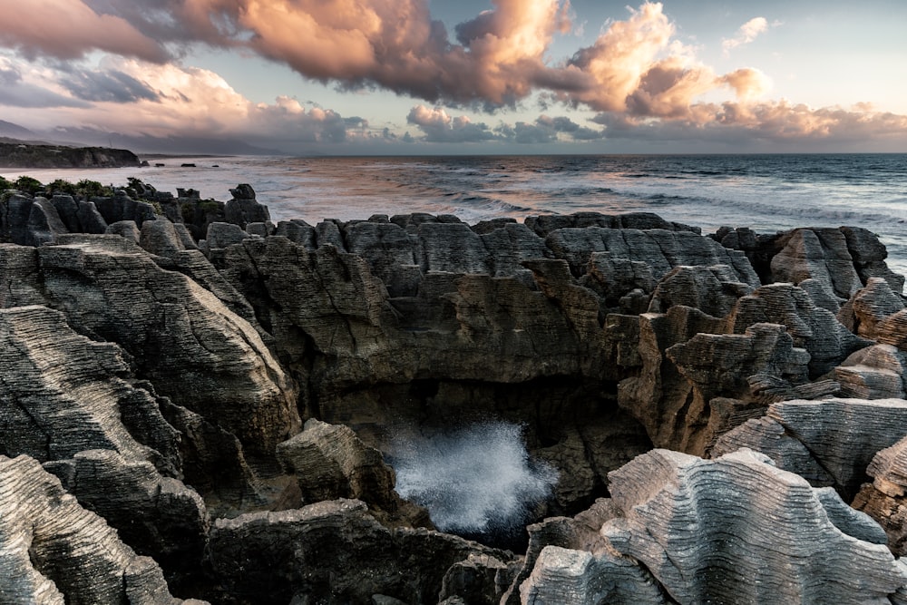 brown rocky mountain near sea waves during daytime