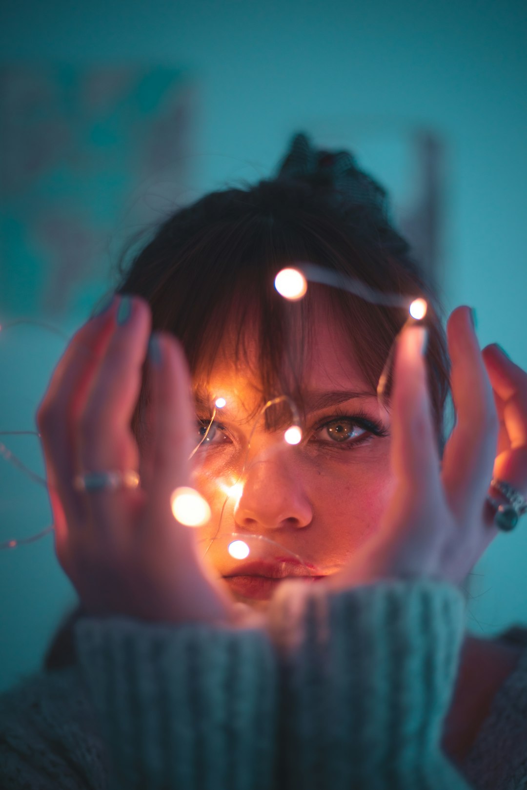 woman in white knit sweater holding lighted candle