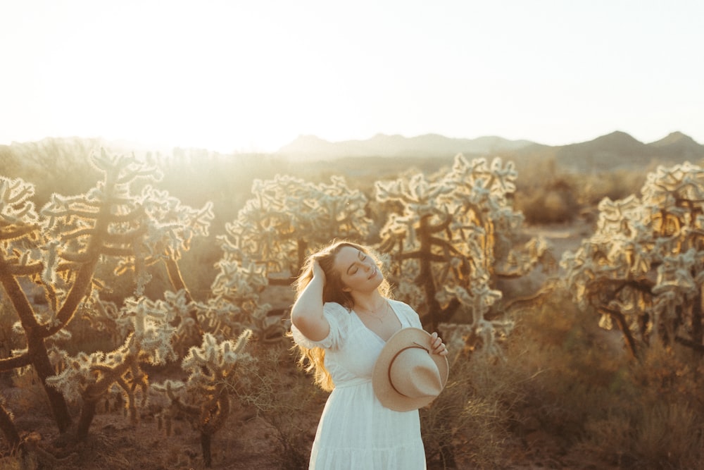 woman in white dress standing on brown flower field during daytime