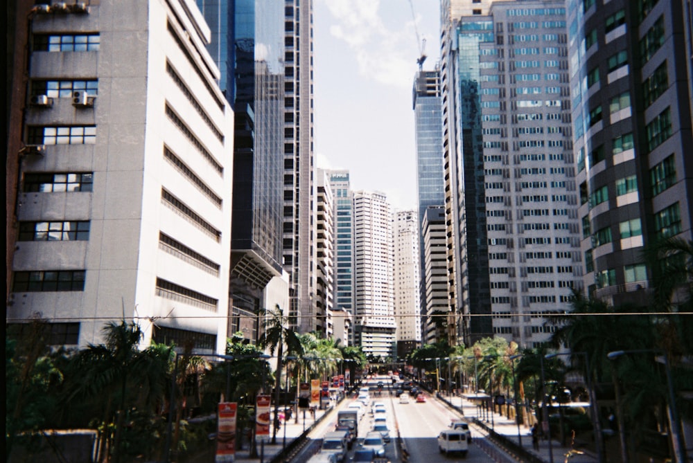 cars on road near high rise buildings during daytime