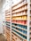 A collection of colorful ceramic mugs arranged neatly on a wooden shelf.
