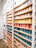 A collection of colorful ceramic mugs arranged neatly on a wooden shelf.