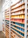 Close-up image of colorful custom printed mugs displayed on a wooden shelf.