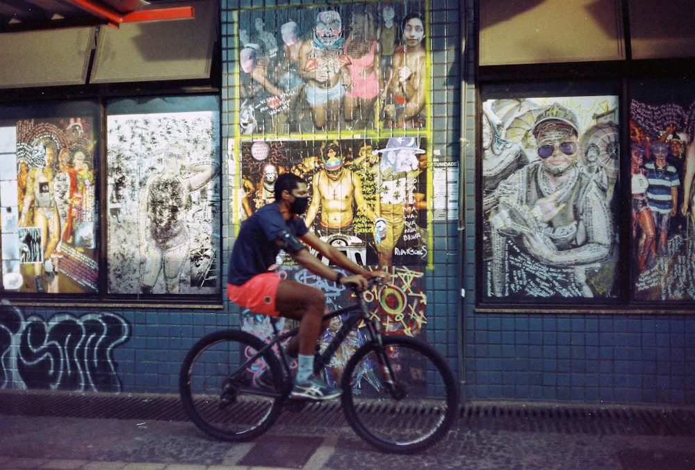 man in blue crew neck t-shirt riding on black bicycle