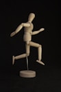brown wooden human figure on black table