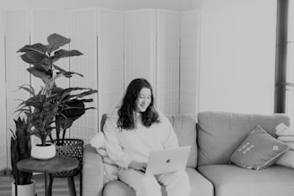 A person engaging with an online health course on a laptop, surrounded by plants and wellness items.