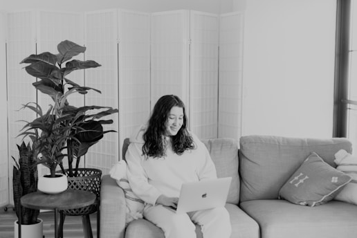A person engaging with an online health course on a laptop, surrounded by plants and wellness items.