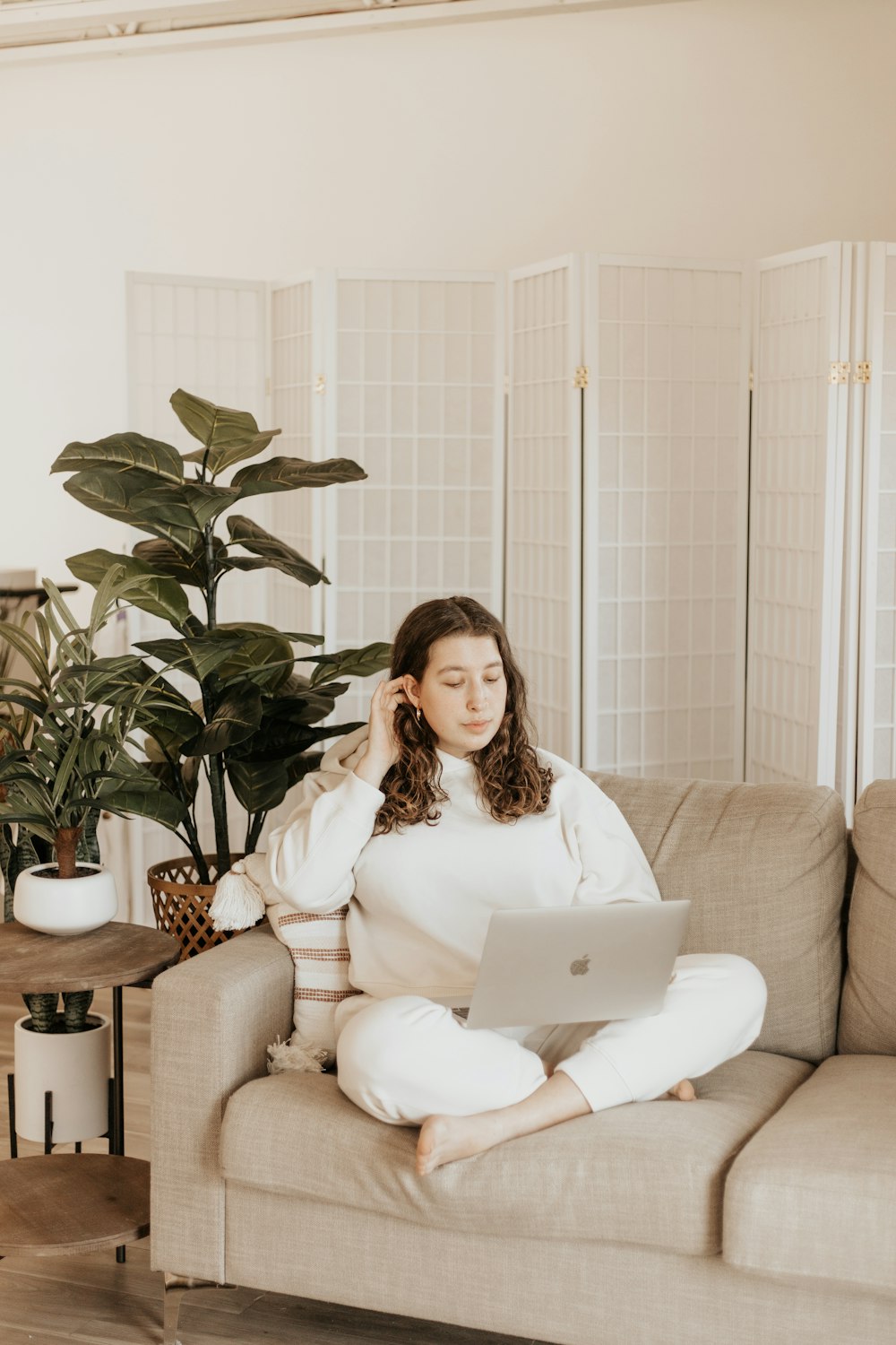 woman in white long sleeve shirt sitting on white sofa