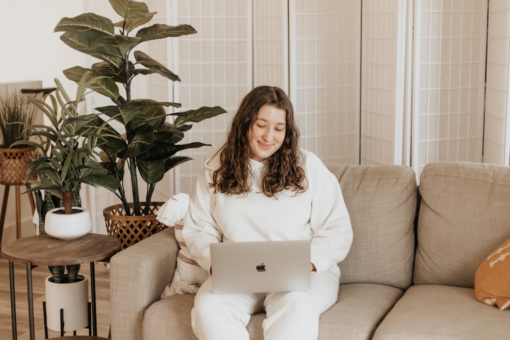 woman in white long sleeve shirt sitting on brown sofa