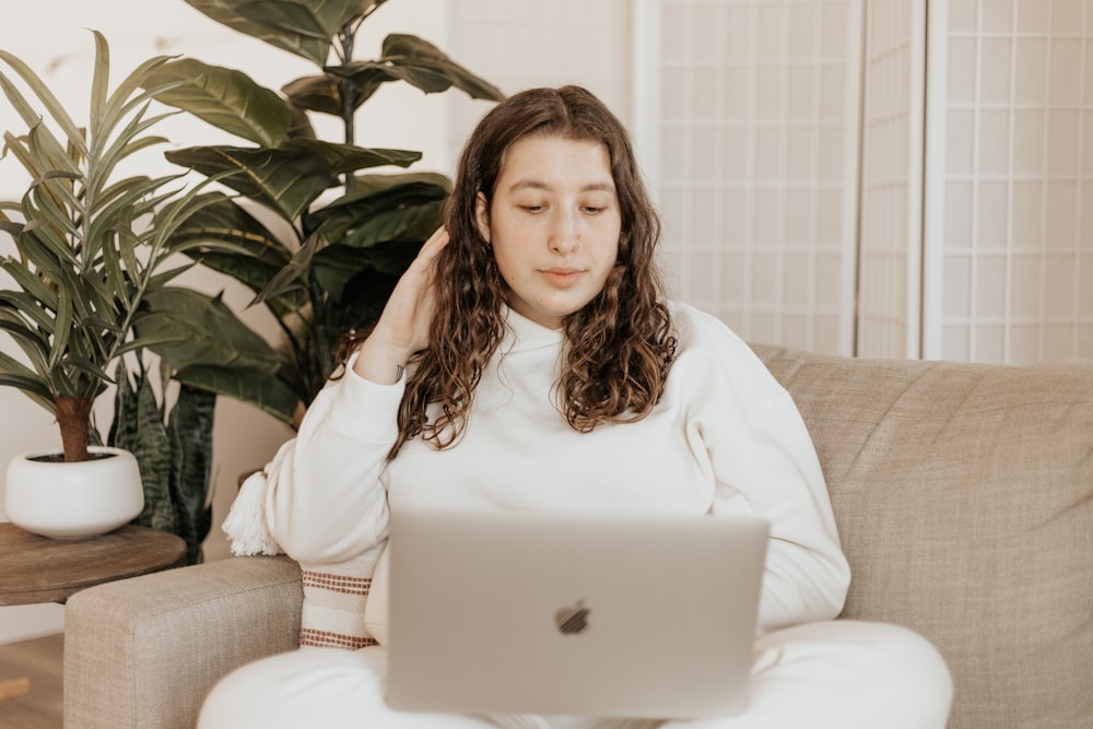 woman in white long sleeve shirt sitting on white couch