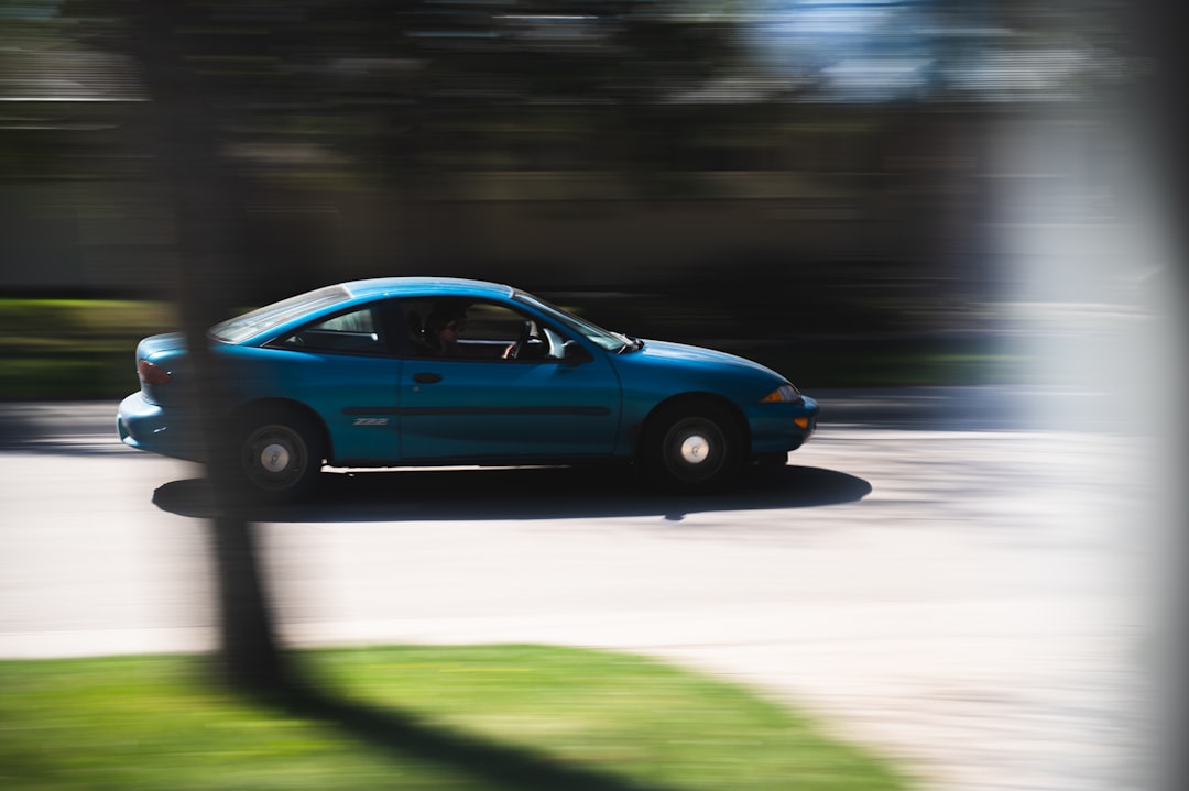 blue sedan on road during daytime