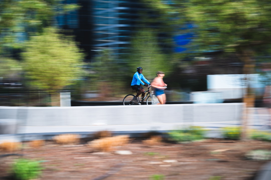 man in green shirt riding bicycle on road during daytime