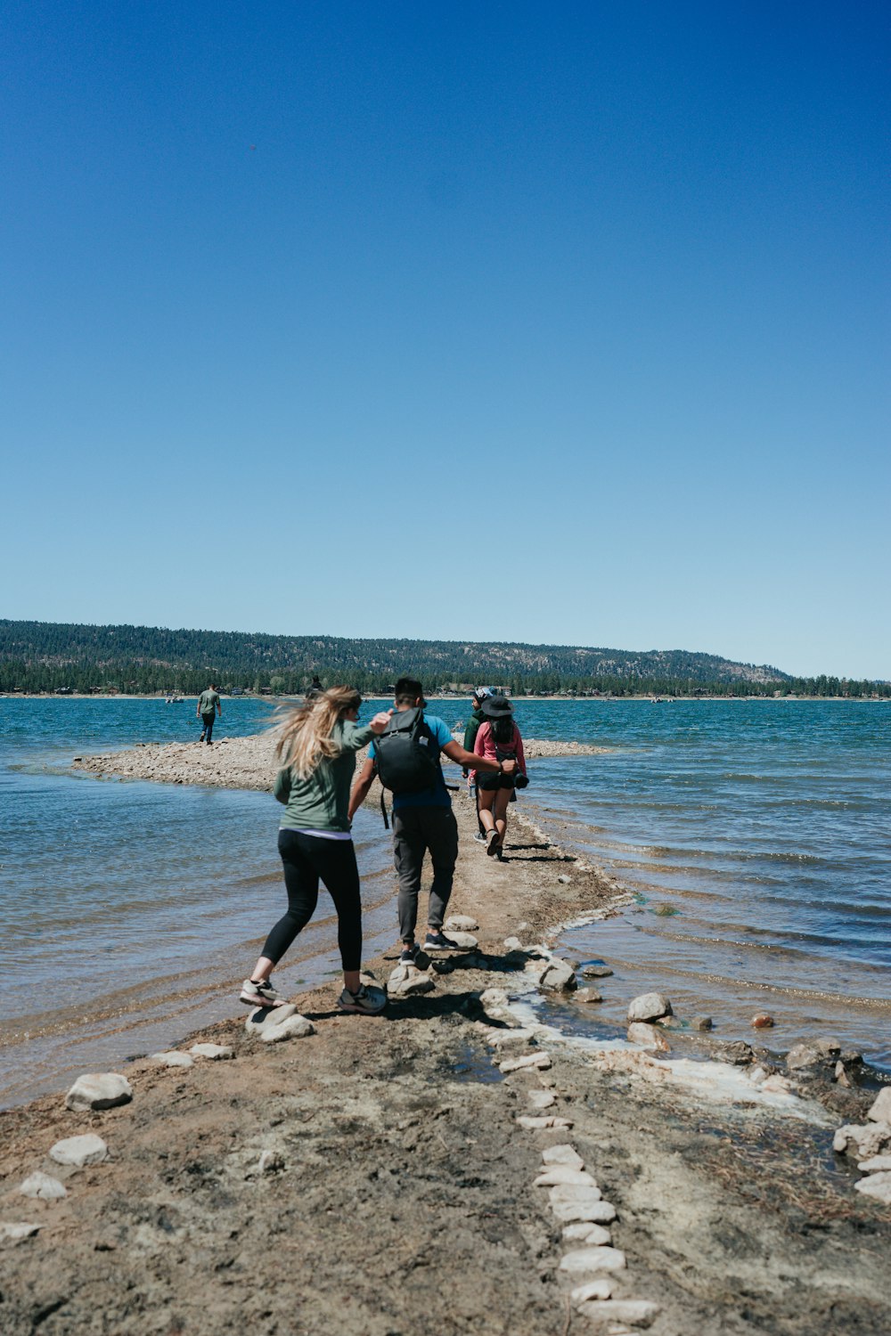 people standing on brown rock near body of water during daytime