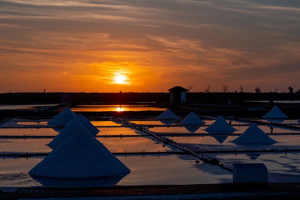 Maisons blanches et grises près du plan d’eau au coucher du soleil