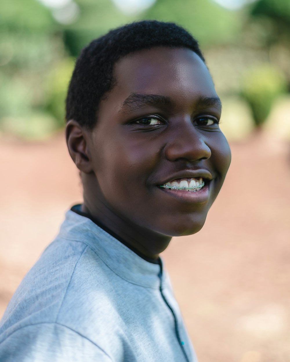 smiling boy in gray polo shirt