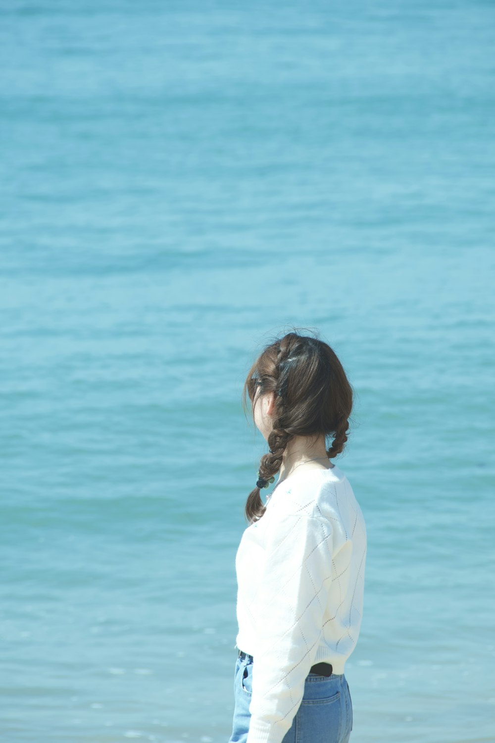 woman in white long sleeve shirt standing near body of water during daytime