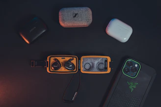 A sleek arrangement of smartphone cases, chargers, and earbuds on a wooden table with soft natural light.