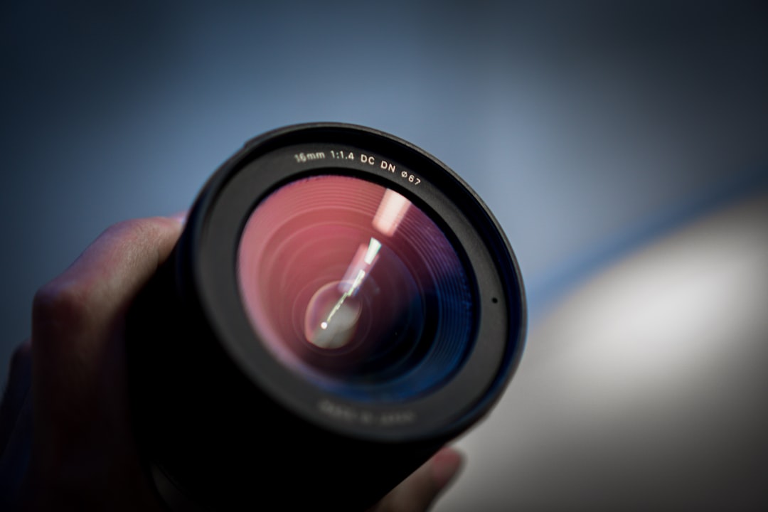 person holding black camera lens