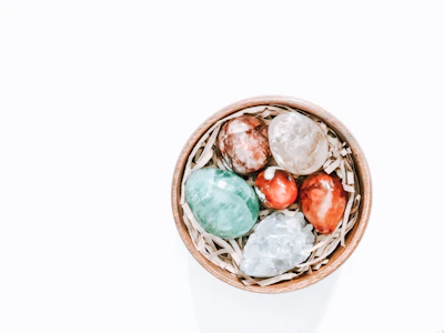 Warm-toned amethyst stones arranged artfully beside a hand-thrown ceramic bowl.