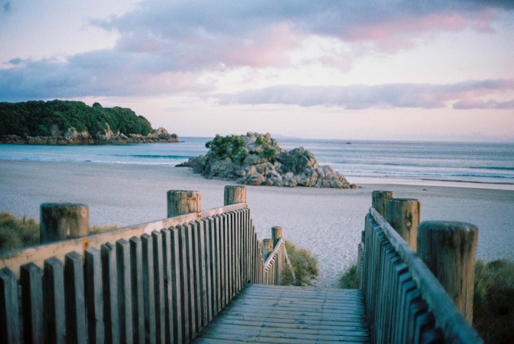 brown wooden dock on blue sea under white clouds during daytime