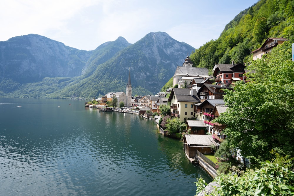 houses near body of water and mountain during daytime