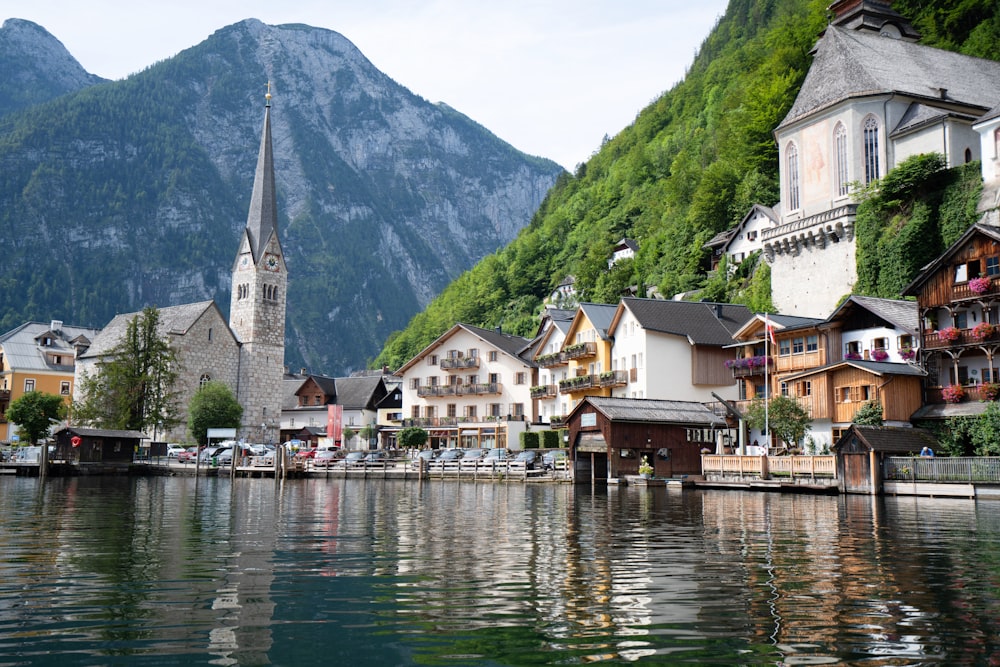 houses near body of water and mountain during daytime