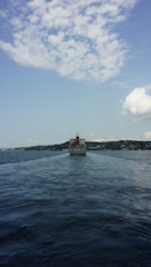 A vessel navigating through calm waters on a relocation journey.