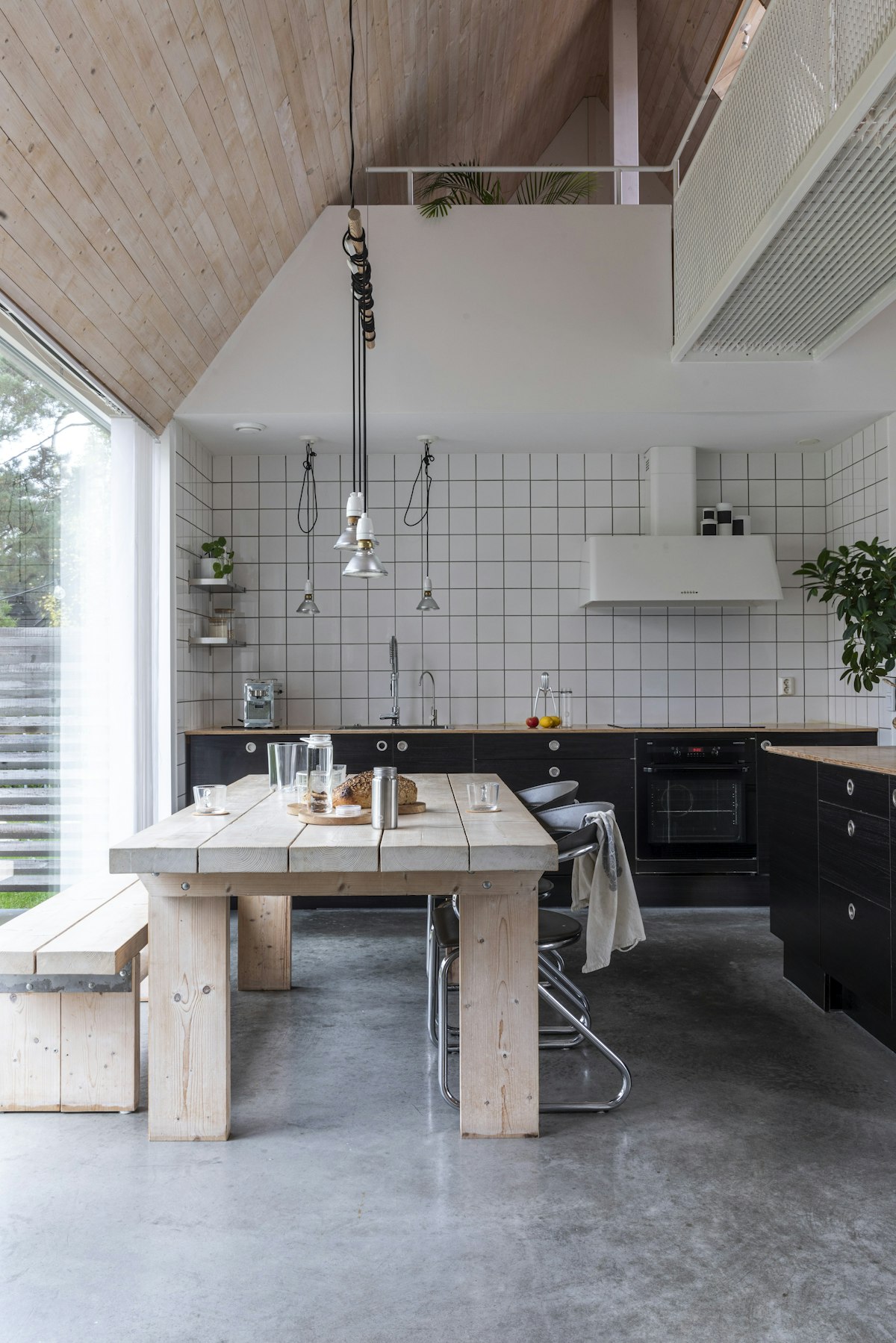 A calm Scandinavian kitchen with a long wooden table and soft daylight