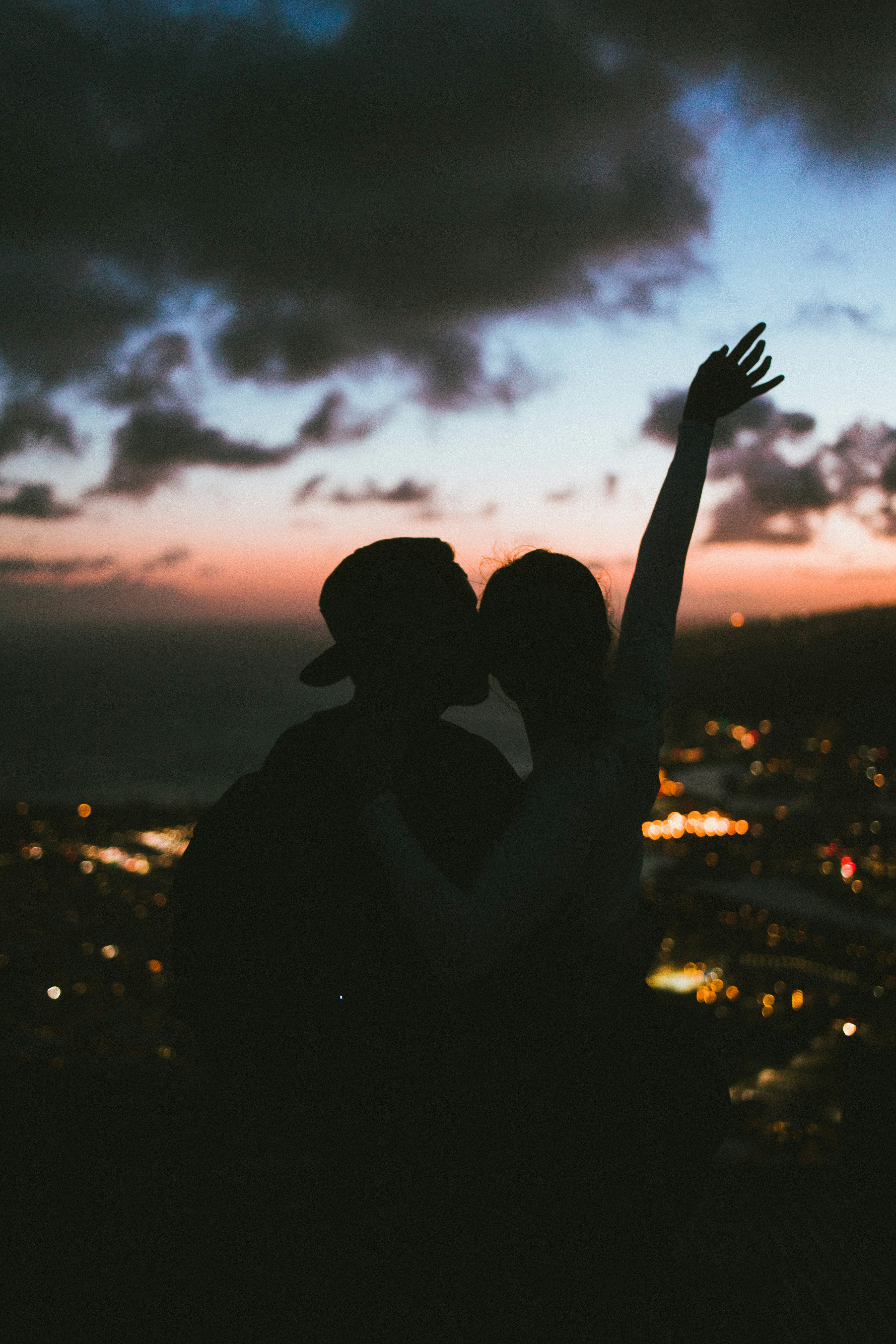 silhouette of man and woman kissing during sunset