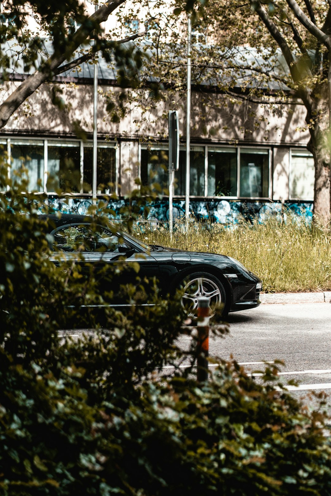 black coupe parked on sidewalk during daytime